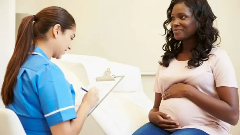 Enfermeira obstetra realizando consulta pré-natal com gestante, destacando a atuação clínica especializada e o cuidado centrado na mulher.