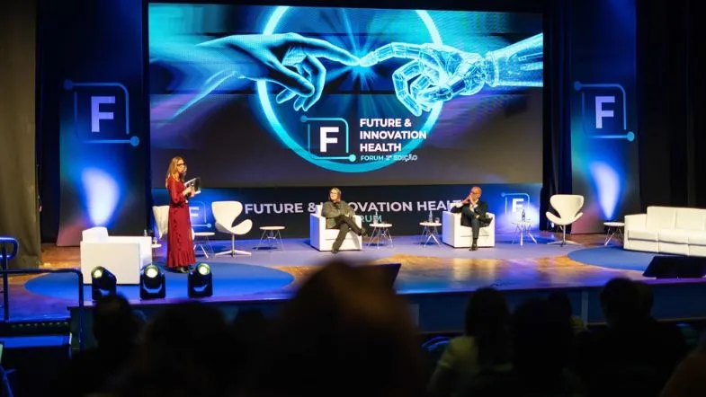 Faculdade ITH participa do HIF 2026, maior evento de inovação hospitalar do Brasil 7 Painel do evento HIF 2026 com profissionais discutindo inovação e futuro da saúde, com projeções interativas em tela.