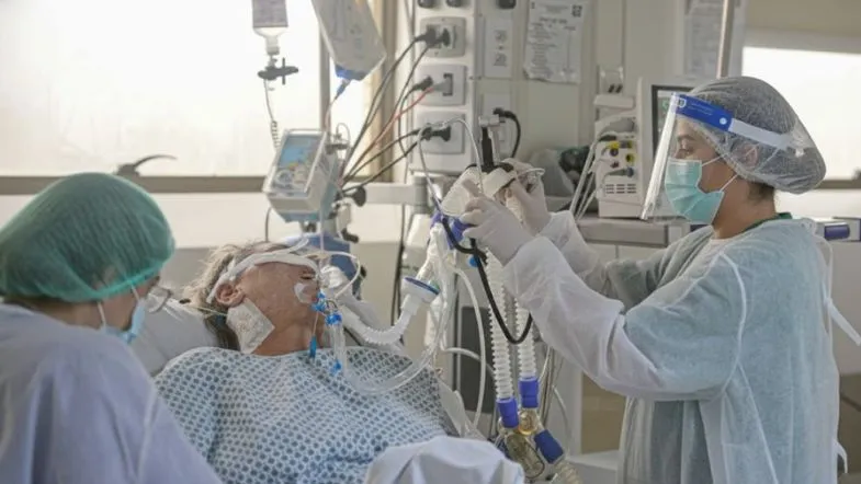 Equipe multiprofissional atuando em unidade de terapia intensiva, aplicando protocolos de segurança do paciente e cuidados críticos.