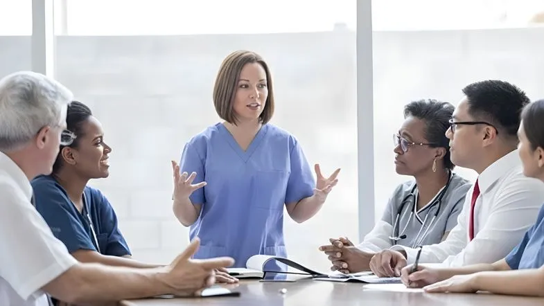 Enfermeira liderando reunião com equipe multiprofissional de saúde, simbolizando gestão, liderança e tomada de decisão coletiva.